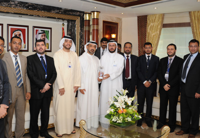 Ahmed Madani presenting the award to HE Ahmed Butti Ahmed with attending officials either side Ahmed Madani presenting the award to HE Ahmed Butti Ahmed with attending officials either side